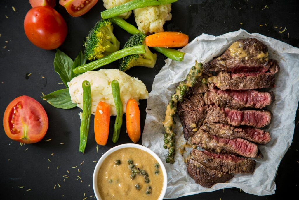 L'immagine mostra una tagliata di bovino al sangue con verdure croccanti, piatto che parla dei segni di fuoco a tavola, in particolare dell'Ariete