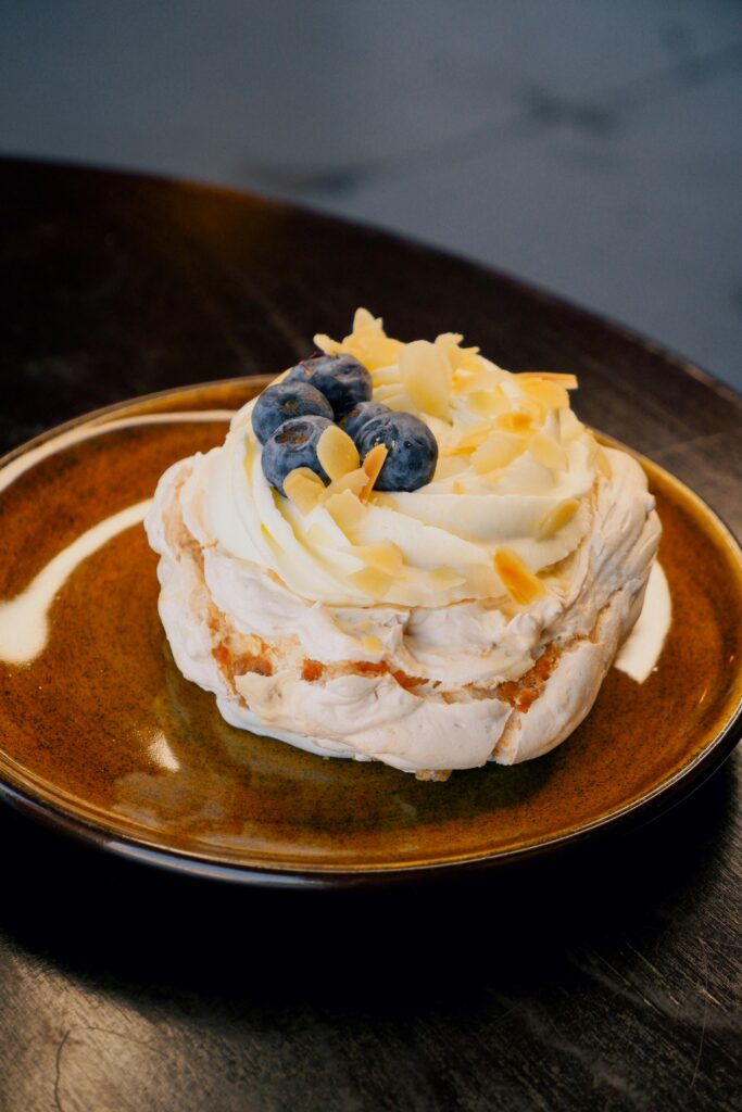 L'immagine mostra una mini pavlova, un dessert a base di meringa, panna e mirtilli freschi