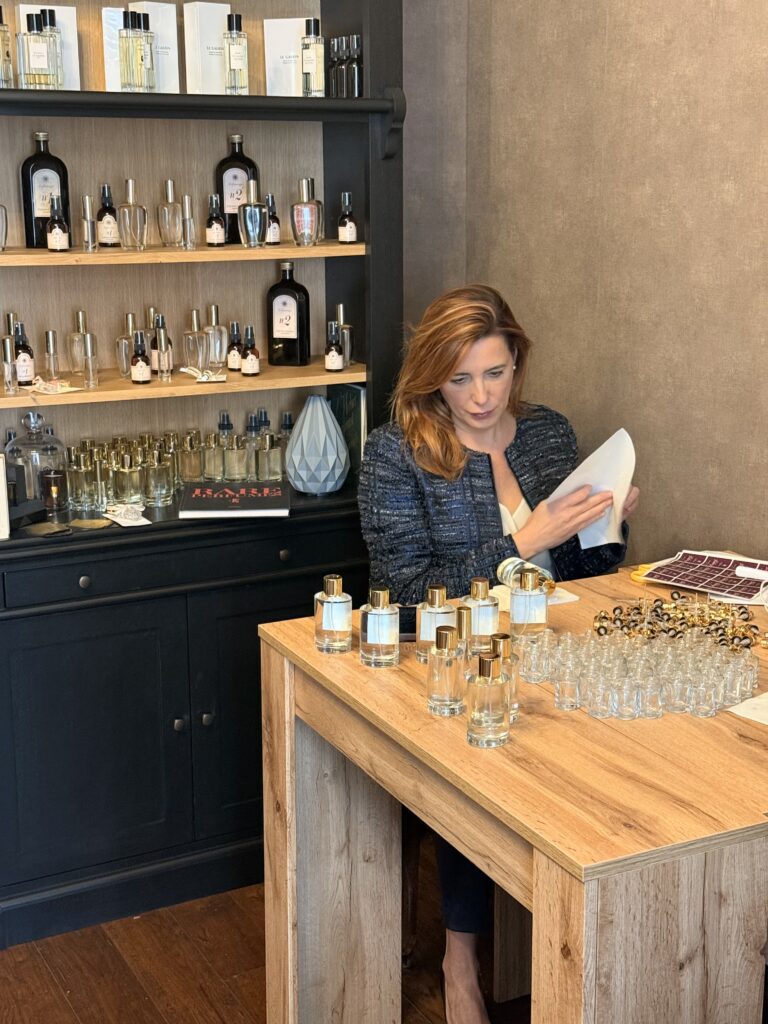Donna appone le etichette sui flaconi di eau de toilette, i profumi di Venere