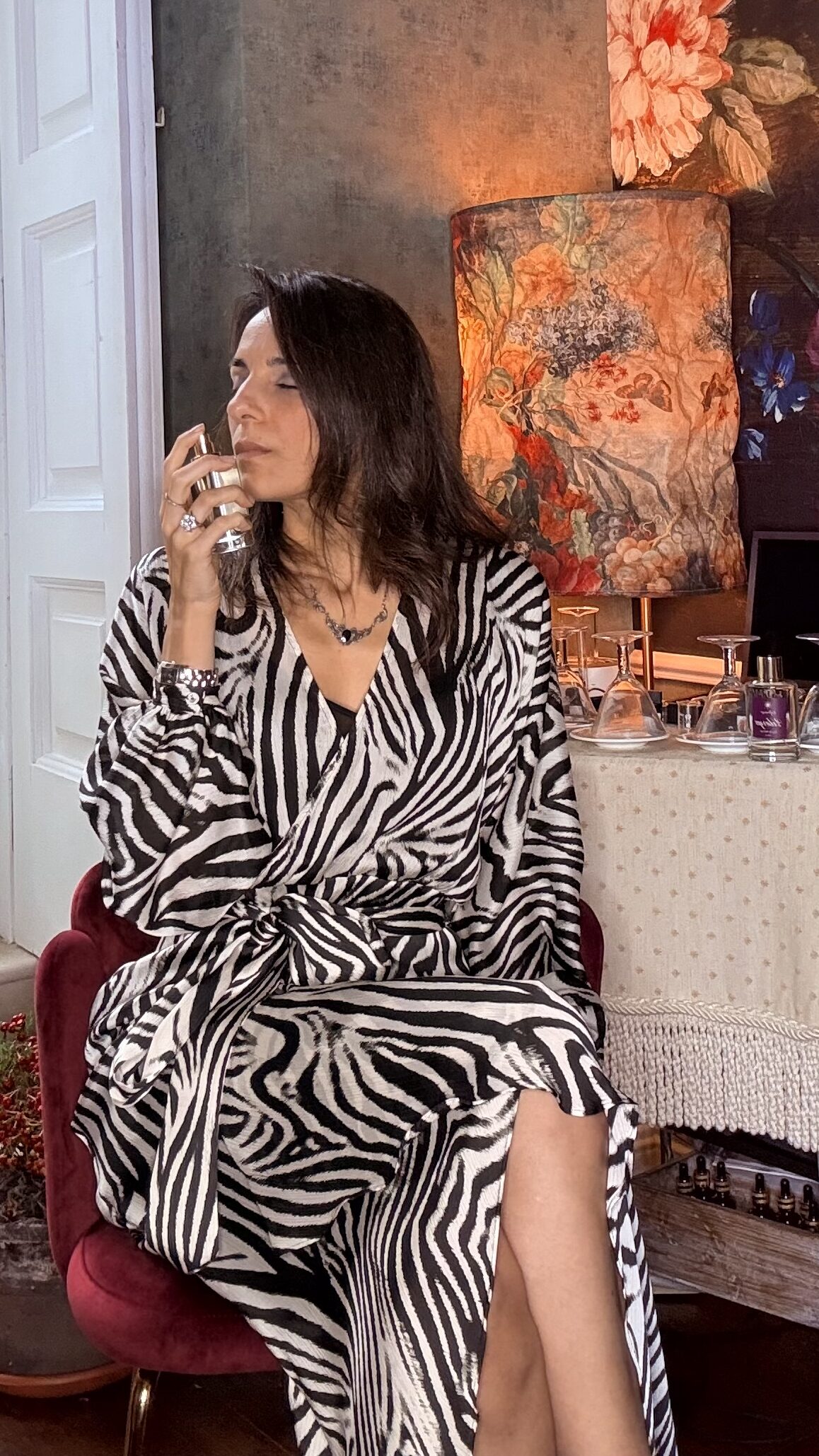 Donna con abito animalier annusa i profumi di Venere